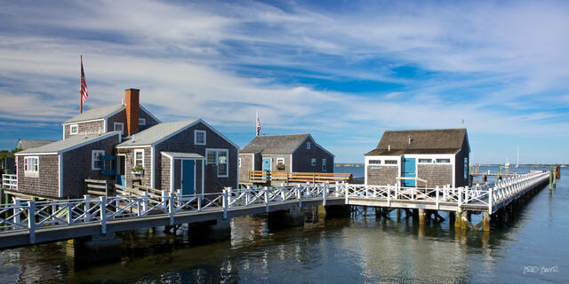Historic gray shingled fishing shacks on a wooden pier at Straight Wharf, Nantucket, Massachusetts