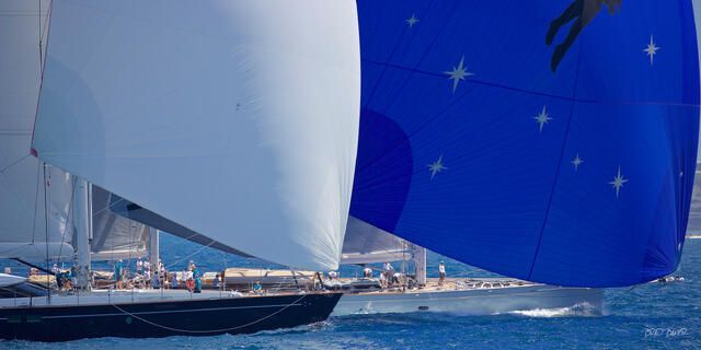 Two large racing yachts sailing downwind with spinnakers deployed on sparkling blue St Barts waters in the Caribbean