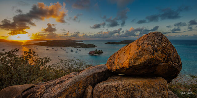 Golden hour panoramic view over North Sound BVI, with Saba Rock resort and anchored yachts at sunset.