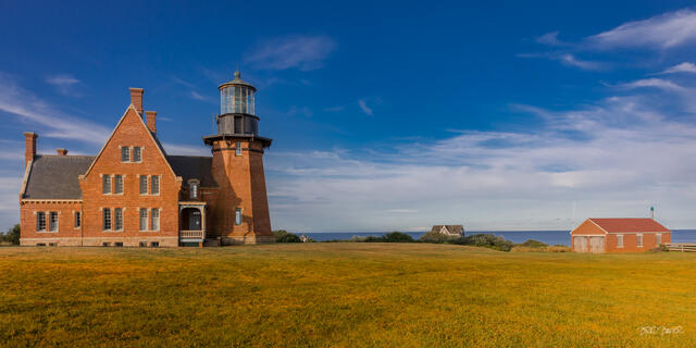 Southeast Lighthouse's brick keeper's house and tower under a blue sky on Block Island, Rhode Island