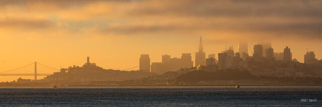 Oakland Bay Bridge and San Francisco skyline emerging through morning haze and fog at sunrise