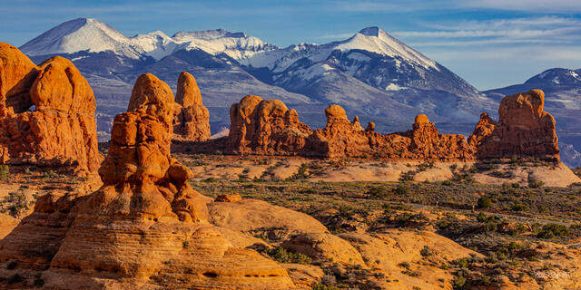 Red rock hoodoos in Arches National Park framed by snow-capped La Sal Mountains, Utah
