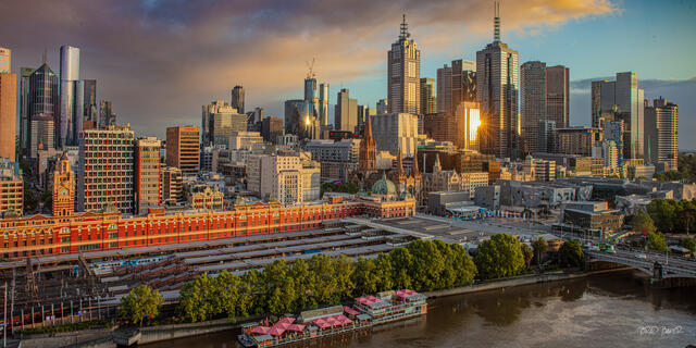 Melbourne skyline glowing in early morning light above Flinders Street Station and the Yarra River