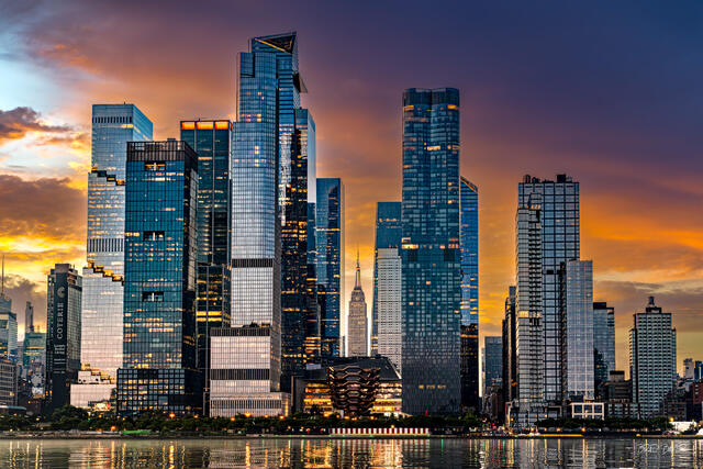 Hudson Yards skyscrapers glow at sunset with the Empire State Building framed between them