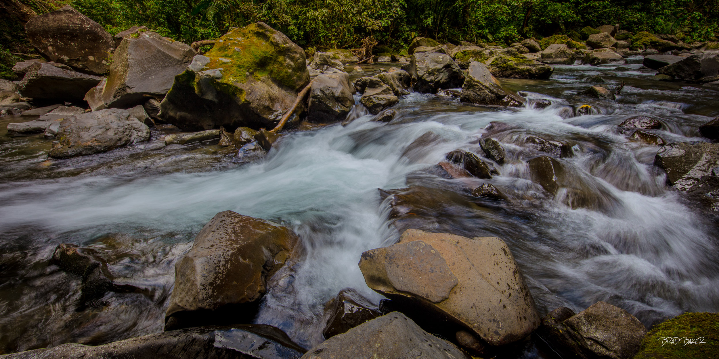 Rythm of the Jungle Long exposure of rushing white water rapids cascading over mossy boulders through dense Costa Rican rainforest