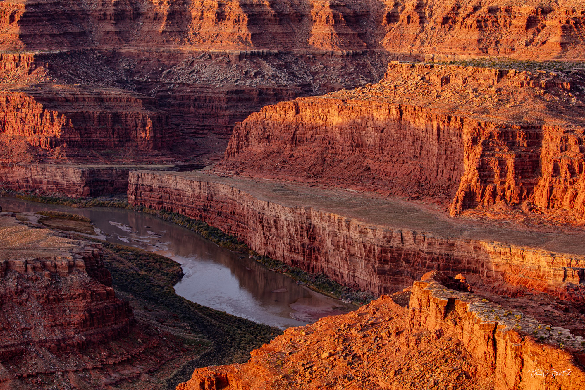 Carving the Path Aerial view of the Colorado River winding through layered red rock canyon walls near Moab, Utah