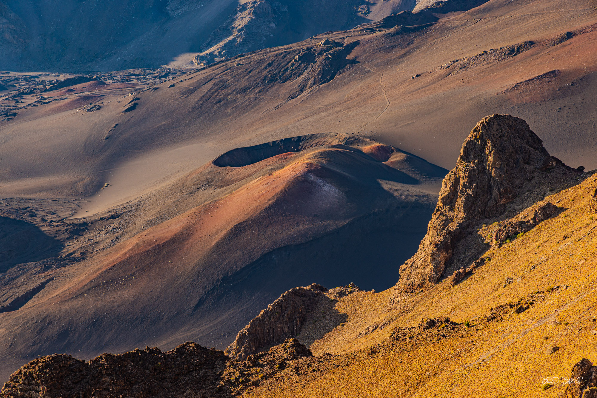 Holy Haleakela Aerial view of Haleakala volcanic crater in Maui with a cinder cone glowing in warm morning light.