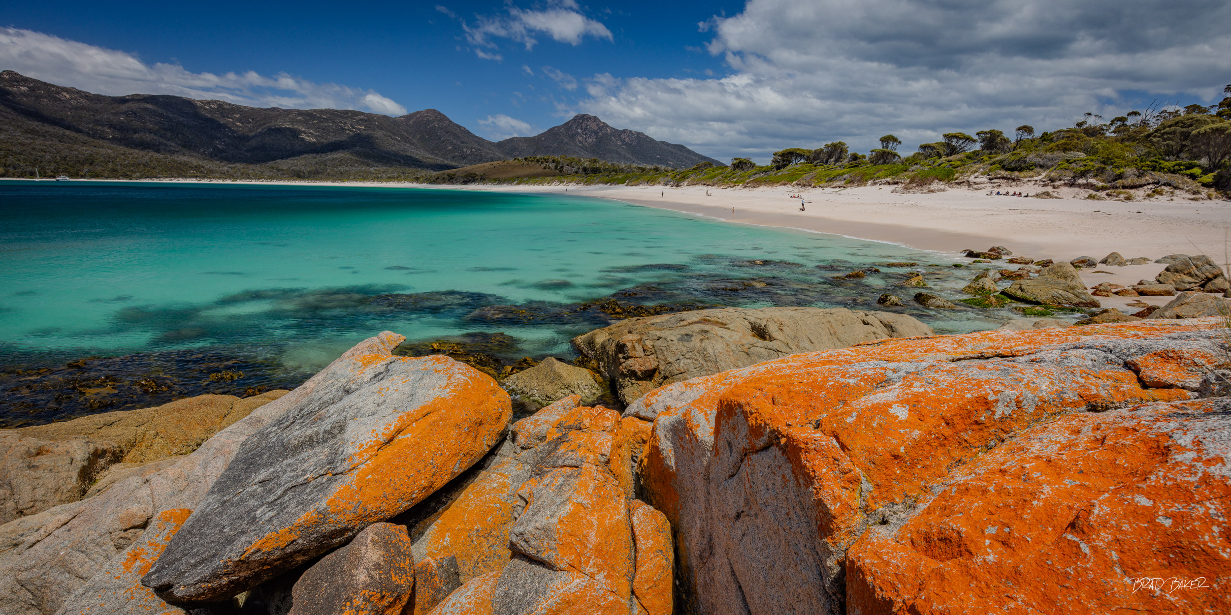 COLORFUL COASTLINE Turquoise waters, orange lichen-covered rocks and white sand at Wineglass Bay, Tasmania