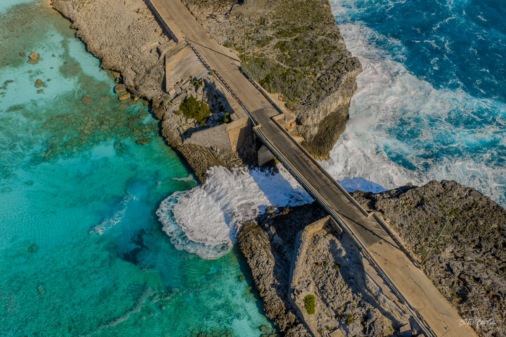 THE GLASS WINDOW Aerial view of a coastal bridge spanning turquoise water and crashing Atlantic waves at The Glass Window Eleuthera Island Bahamas