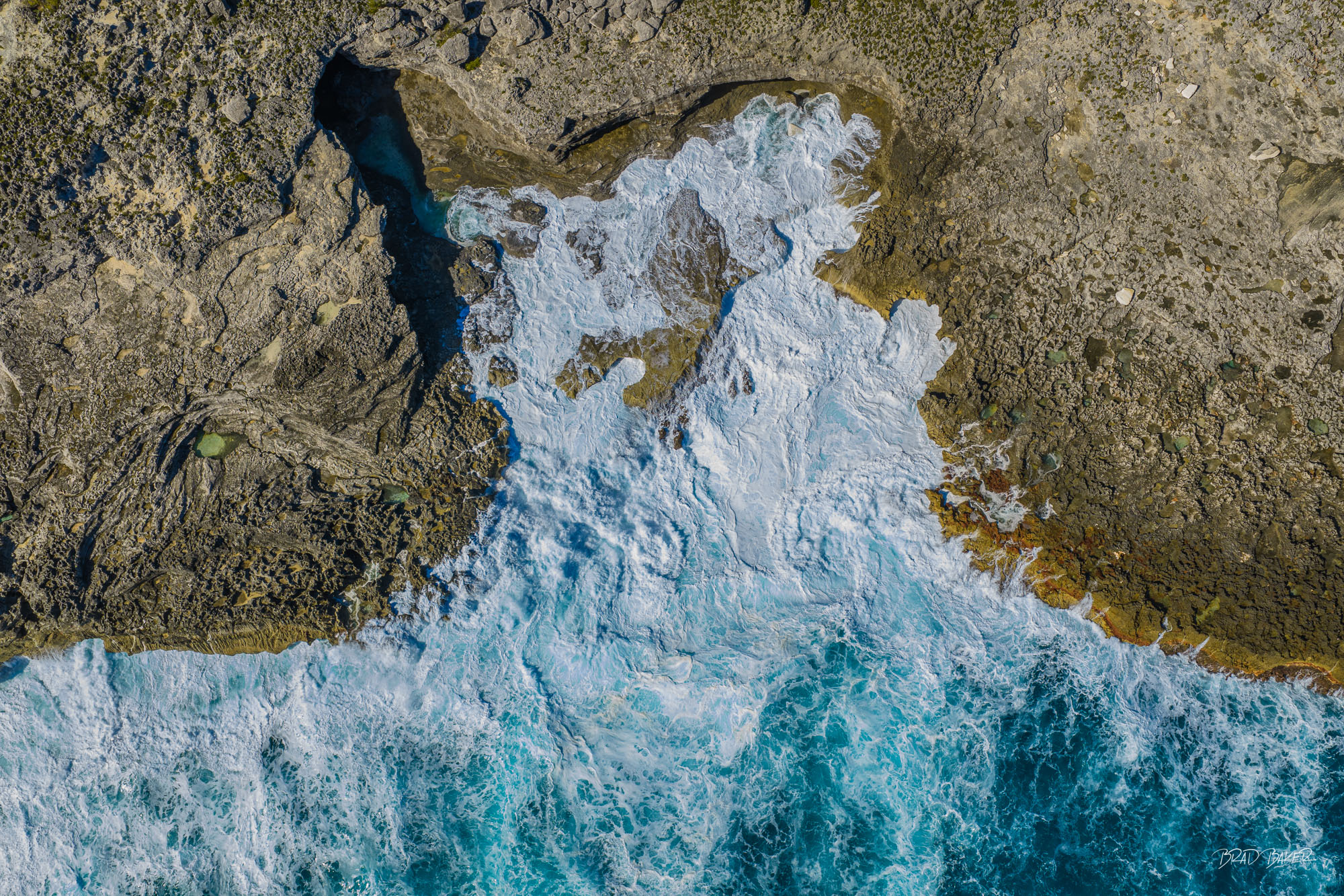 THE QUEEN'S BATHS Aerial view of foamy ocean waves washing over a rugged rocky coastal pool at The Queens Baths Eleuthera Island Bahamas